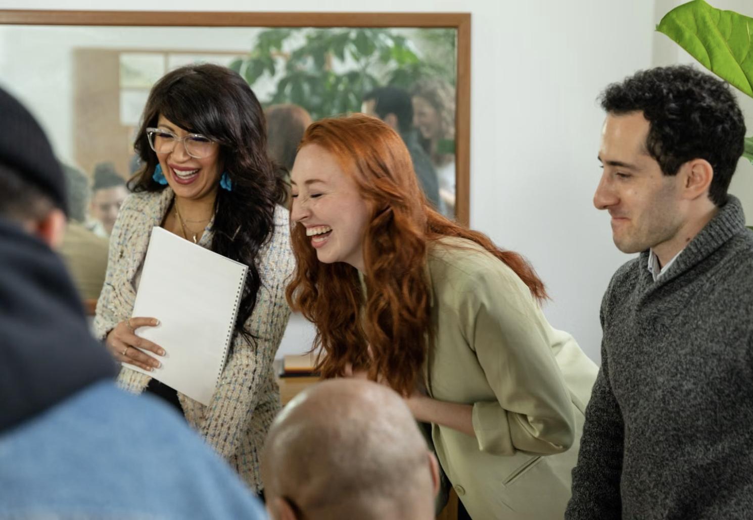 Bellabay colleagues laughing together while reviewing papers